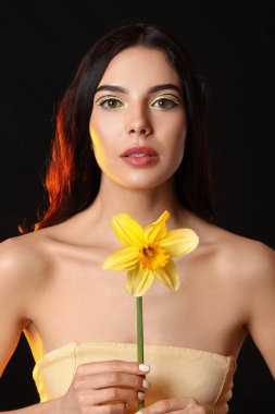 Şık makyajlı ve koyu renkli çiçekli güzel bir kadın.