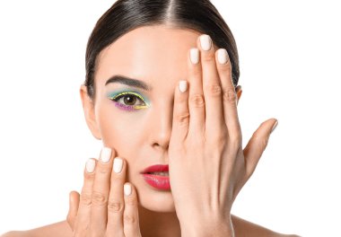 Beyaz arka planda şık makyajlı güzel bir genç kadın.