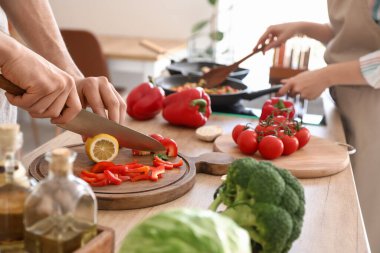 Mutfakta yemek pişiren genç çift, yakın plan.