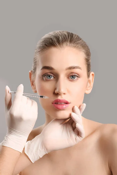 Young Woman Receiving Filler Injection Lips Grey Background — Stock Photo, Image