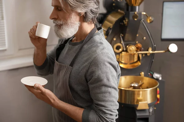 Senior Man Met Kopje Warme Drank Buurt Van Moderne Koffiebranderij — Stockfoto