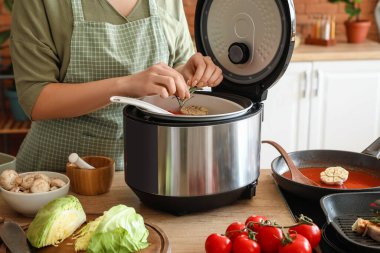 Mutfakta çoklu fırın kullanan bir kadın