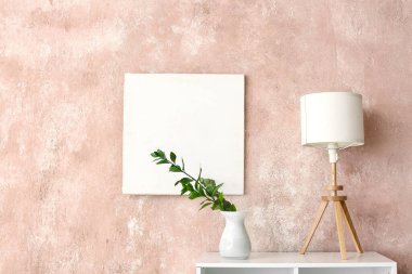 Renk duvarına yakın rafta vazosu olan modern lamba.