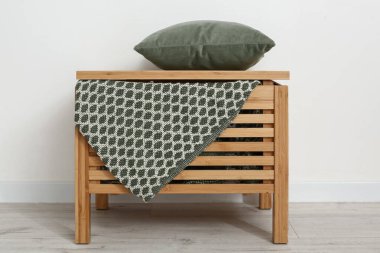 Hafif duvarın yanında yastıklı tahta çekmeceler.