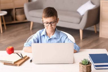 Küçük okul çocuğu evde online çalışıyor.
