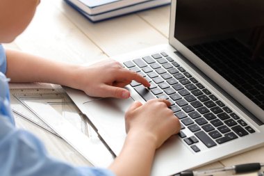 Küçük okul çocuğu evde online çalışıyor.