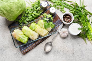 Pişmemiş lahana ruloları ve grunge arkaplanda pişirme yemeği.