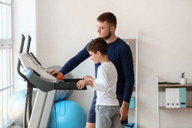 Fizyoterapist rehabilitasyon merkezinde bir çocukla çalışıyor.