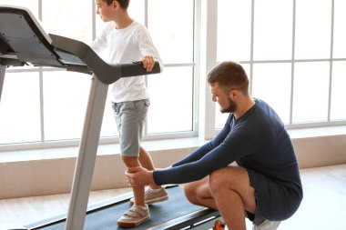 Fizyoterapist rehabilitasyon merkezinde bir çocukla çalışıyor.