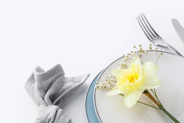 Beyaz arka planda narsist çiçekli güzel bir masa.