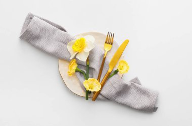 Beyaz arka planda narsis çiçekleri olan güzel bir masa.