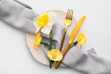 Beyaz arka planda narsis çiçekleri olan güzel bir masa.