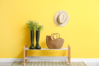 Çizmelerle, papatyalarla ve renkli duvarların yanında durun.