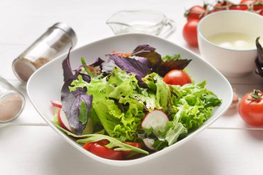 Hafif ahşap arka planda lezzetli taze salata ile kase, yakın plan.