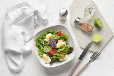 Hafif arka planda taze salata, limon ve baharatlı tabak.