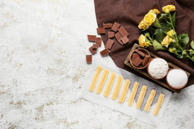 Pişmemiş churros, malzemeler ve çiçekler hafif grunge arka planda