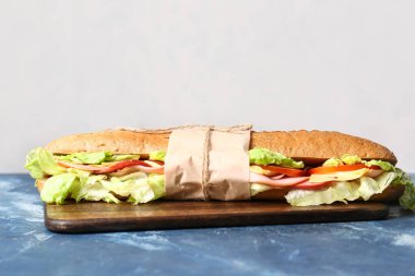 Renkli arkaplanda lezzetli ciabatta sandviçi olan tahta