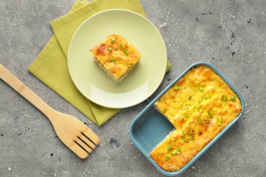 Arkaplanda patates püresi güveci olan tabak ve fırın tabağı.