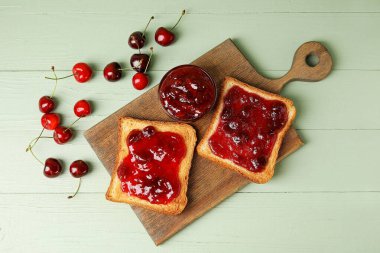 Renkli ahşap arka planda kiraz reçelli tostlar