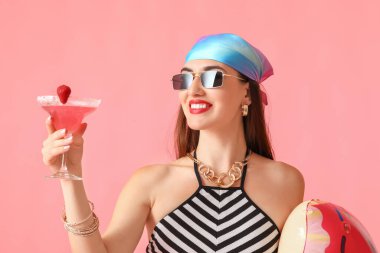 Renkli yüzme yüzüğüyle kokteyl içen güzel bir kadın.