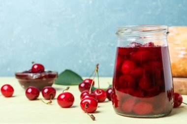 Renkli arkaplanda kiraz reçeli kavanozu