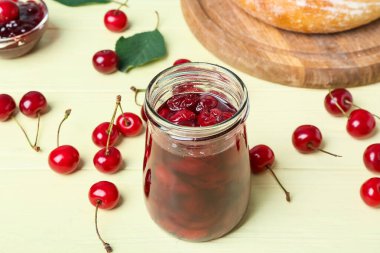 Renkli ahşap arka planda kiraz reçeli kavanozu