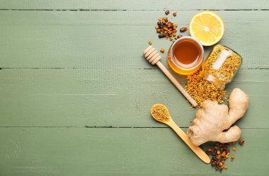 Renkli ahşap arka planda limonlu ve zencefilli farklı arı ürünleri