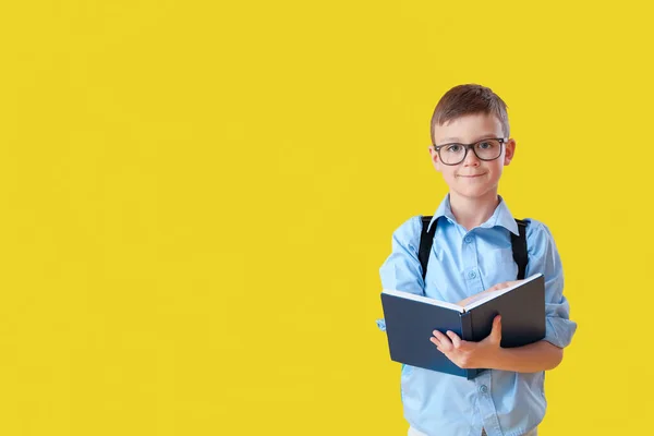 Kleiner Schuljunge Liest Buch Auf Farbigem Hintergrund — Stockfoto