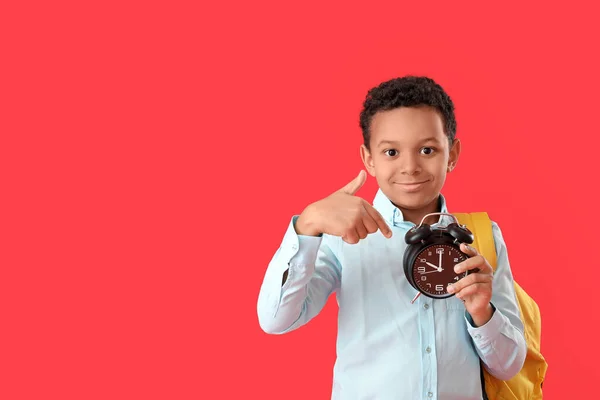 Kleiner Afroamerikanischer Schüler Zeigt Auf Wecker Auf Farbigem Hintergrund — Stockfoto