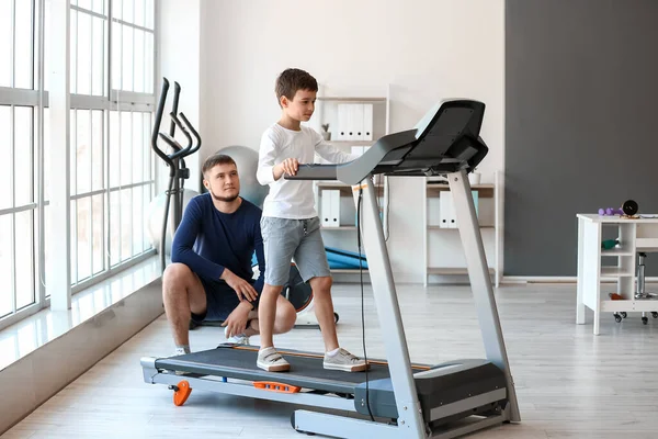 Physiotherapist working with boy in rehabilitation center