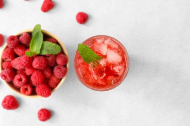 Bir bardak nefis limonata ve arka planda ahududulu kase.