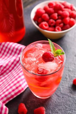 Koyu masada bir bardak ahududu limonatası.