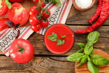 Ahşap arka planda bir bardak lezzetli domates suyu.