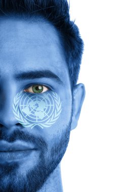 Beyaz arka planda Birleşmiş Milletler bayrağı renginde yüzü olan genç bir adam.