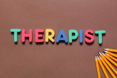Kelime THERAPIST ve renk arkaplanındaki kalemler