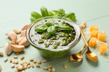 Taze pesto soslu kase ve ahşap kaplamalı malzemeler, yakın plan.