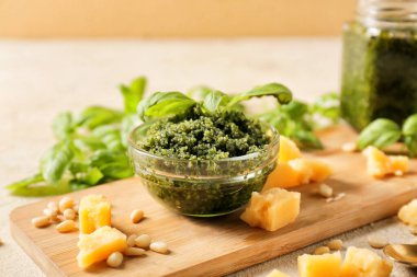 Tahta tahtada taze pesto sosu ve malzemeler var.