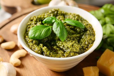 Taze pesto soslu kase ve malzemeler masada, yakın plan.