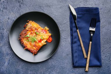 Koyu arkaplanda lezzetli sebzeli lazanya tabağı.