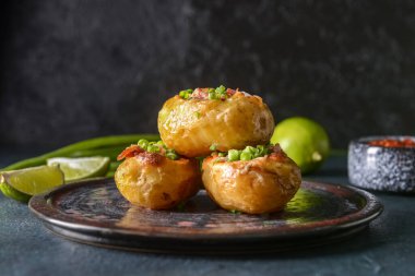 Koyu arkaplanda fırında patates tabağı.