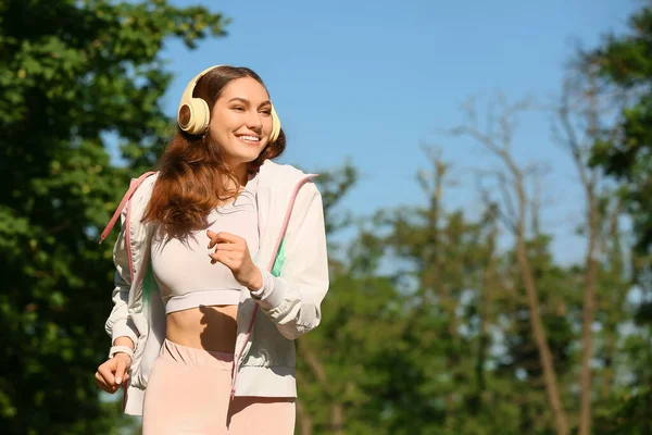 Sportieve Jonge Vrouw Die Naar Muziek Luistert Terwijl Buiten Rent — Stockfoto