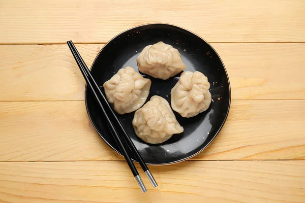 Platta Med Välsmakande Dumplings Och Ätpinnar Trä Bakgrund — Stockfoto