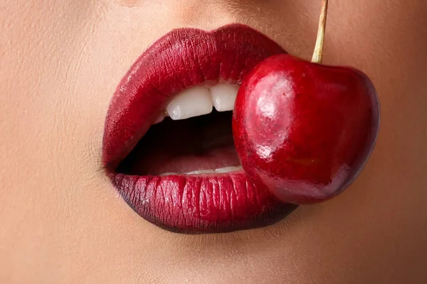 Beautiful young woman with cherry, closeup