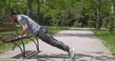 Parkta şınav çeken genç bir adam.