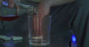 Genç adam gece geç saatte evde içki içiyor.