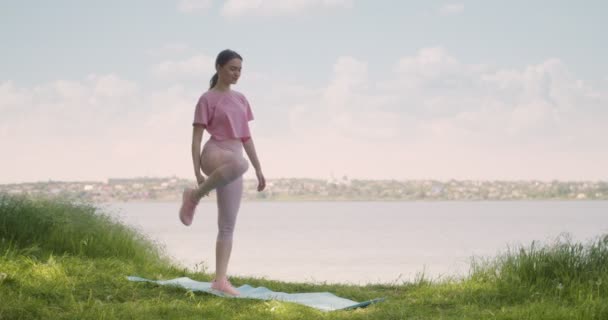 Vacker Ung Kvinna Som Utövar Yoga Nära Floden — Stockvideo