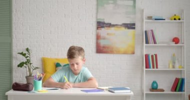 Küçük çocuk evde ders alıyor.