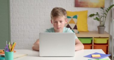 Küçük okul çocuğu evde online çalışıyor.