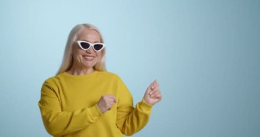 Mutlu, olgun bir kadın dans ediyor.