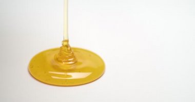 Beyaz arka planda tatlı bal dökülüyor